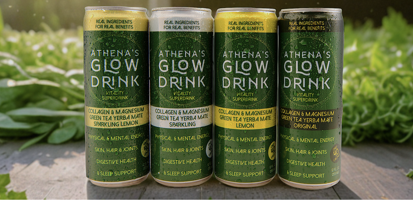 Four cans of Athena's Glow Drink on a wooden surface with greenery in the background