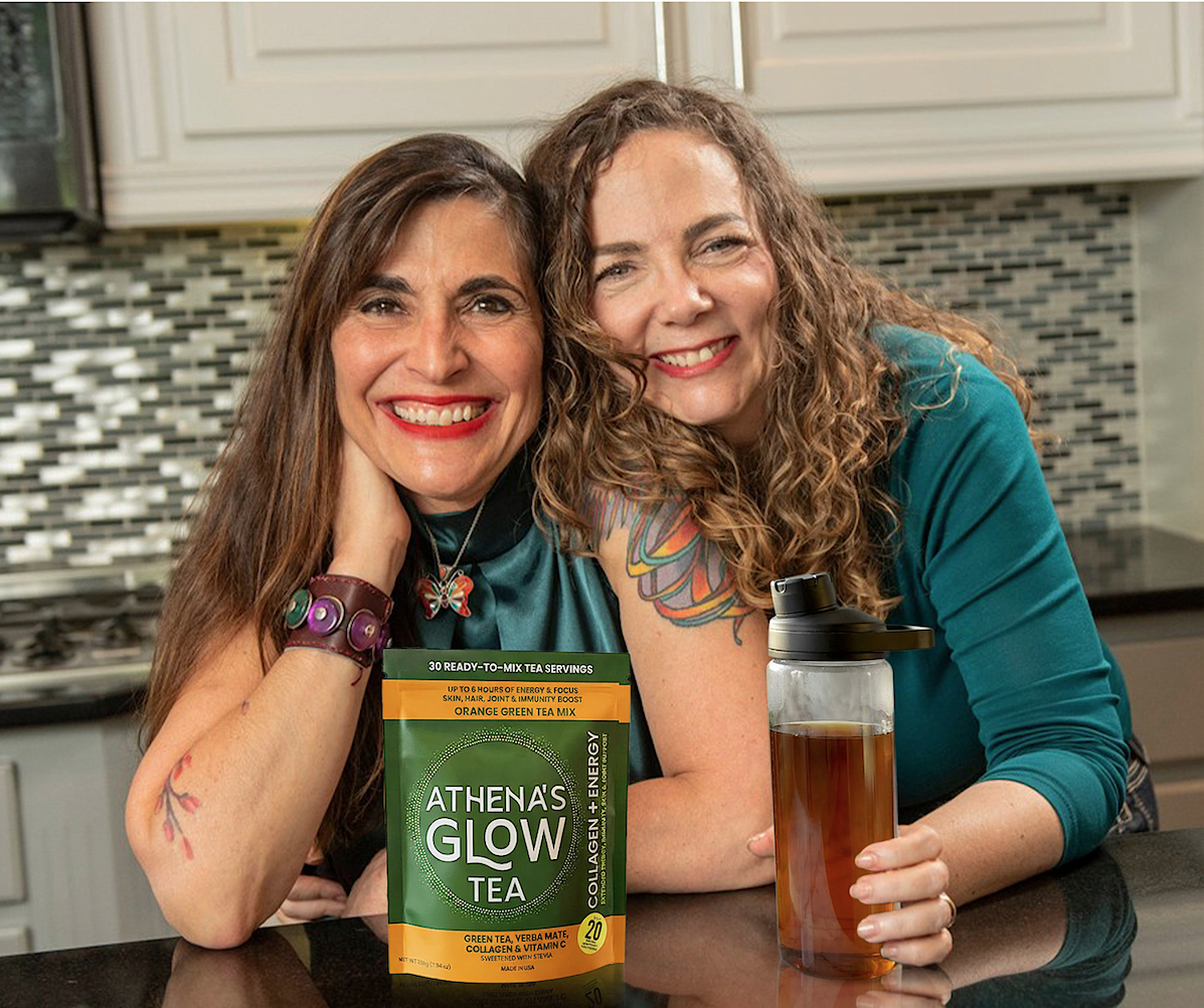 Athena's Glow founders  in a kitchen with Athena's Glow tea packaging and a bottle of tea.