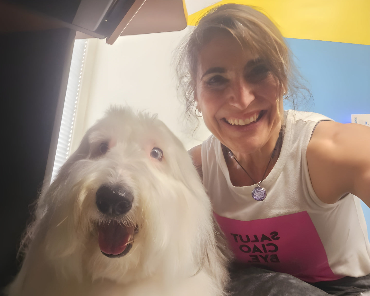 Smiling woman posing with white dog
