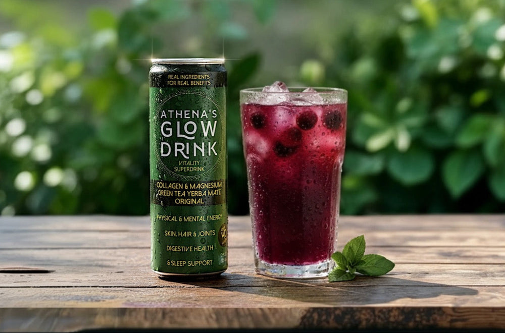 Athena's Glow Drink can and a glass of a cranberry mocktail on a wooden table outdoors.
